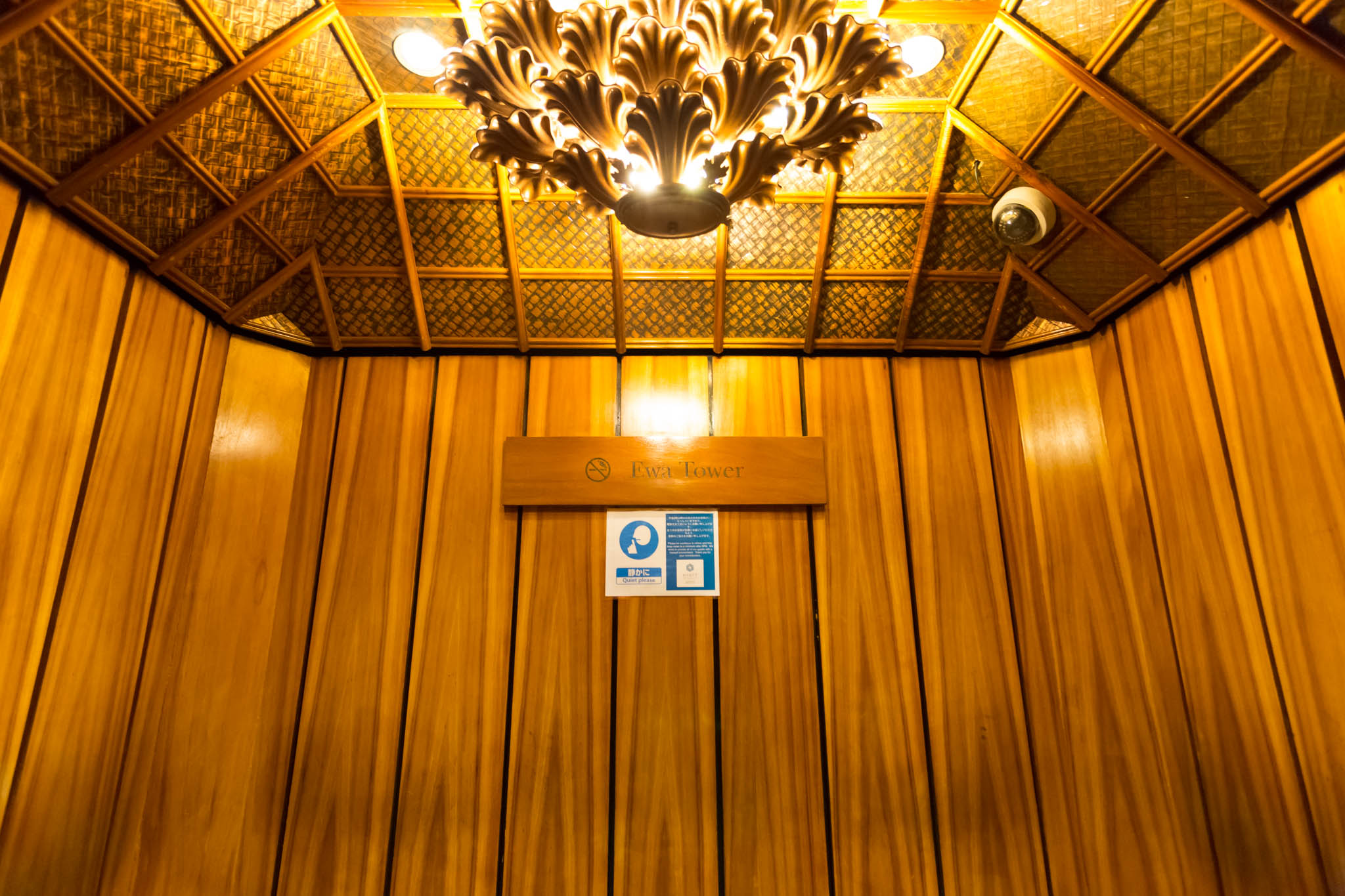 a wooden paneled elevator with a light fixture