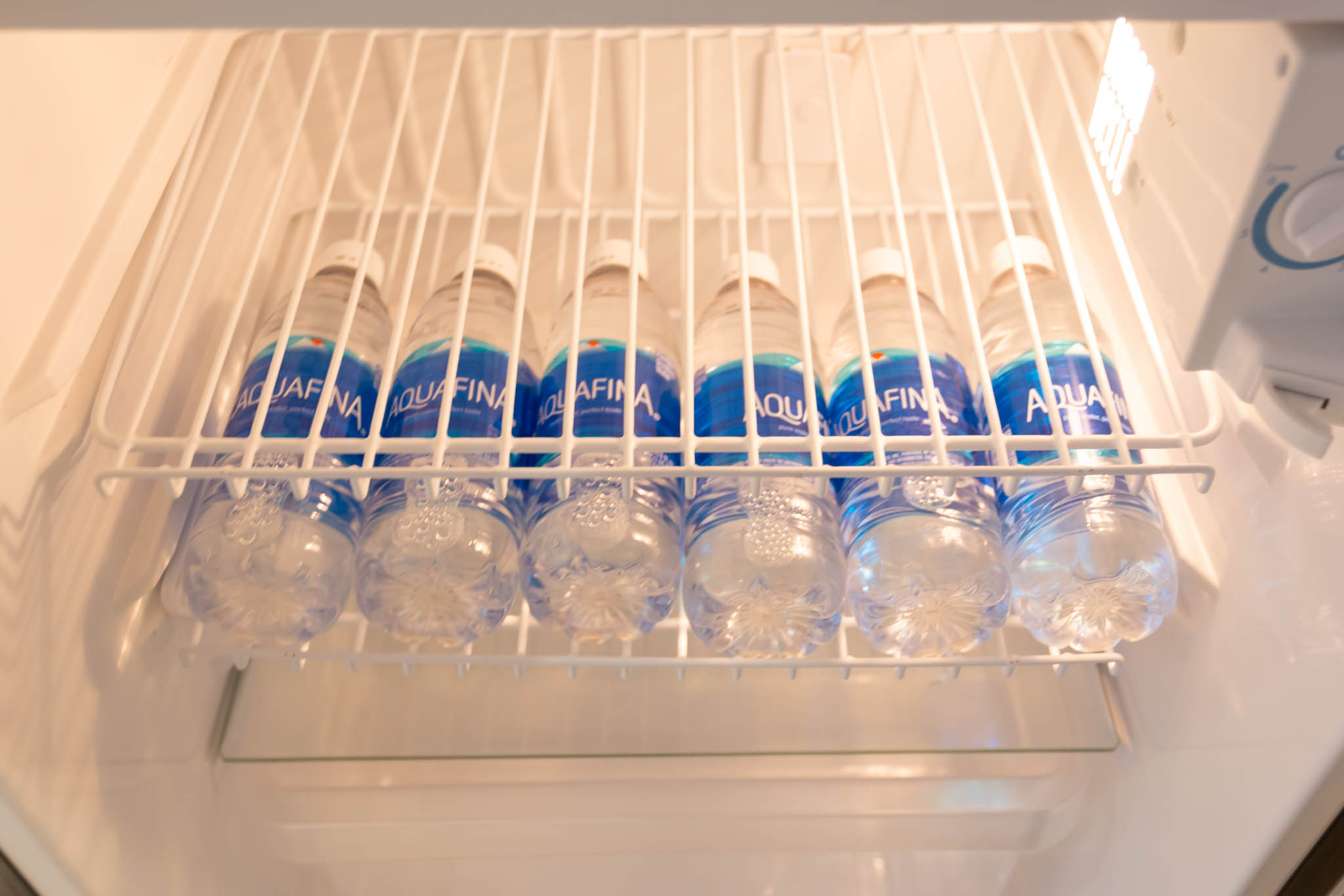 a row of water bottles in a refrigerator