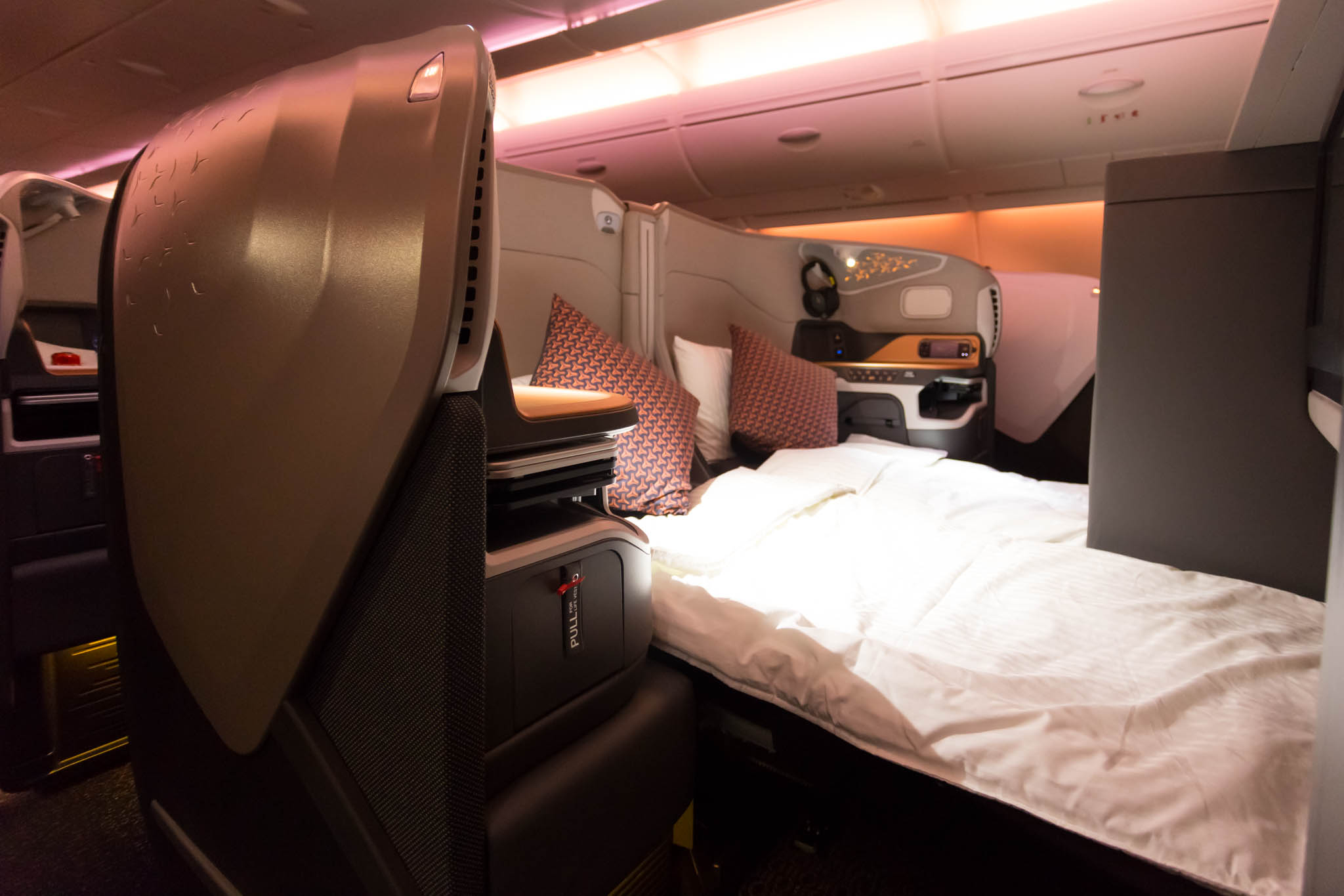 a bed and a chair in an airplane