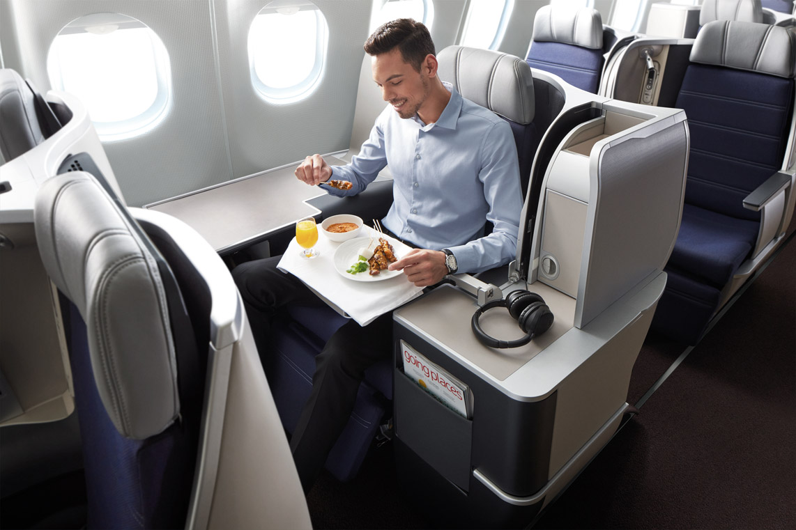 a man eating food on an airplane
