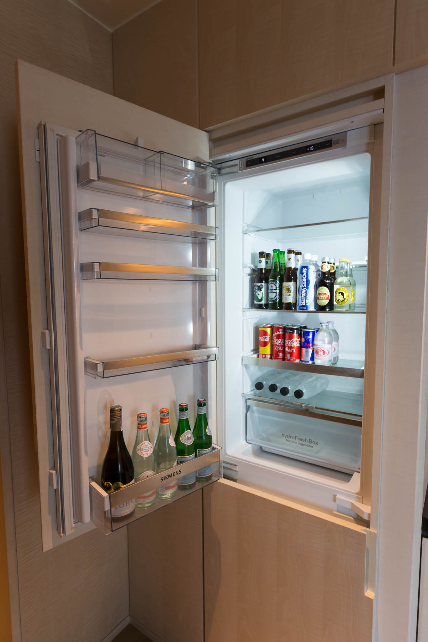 a refrigerator with bottles of beer and bottles of soda