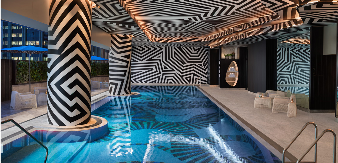 a swimming pool with a black and white patterned wall