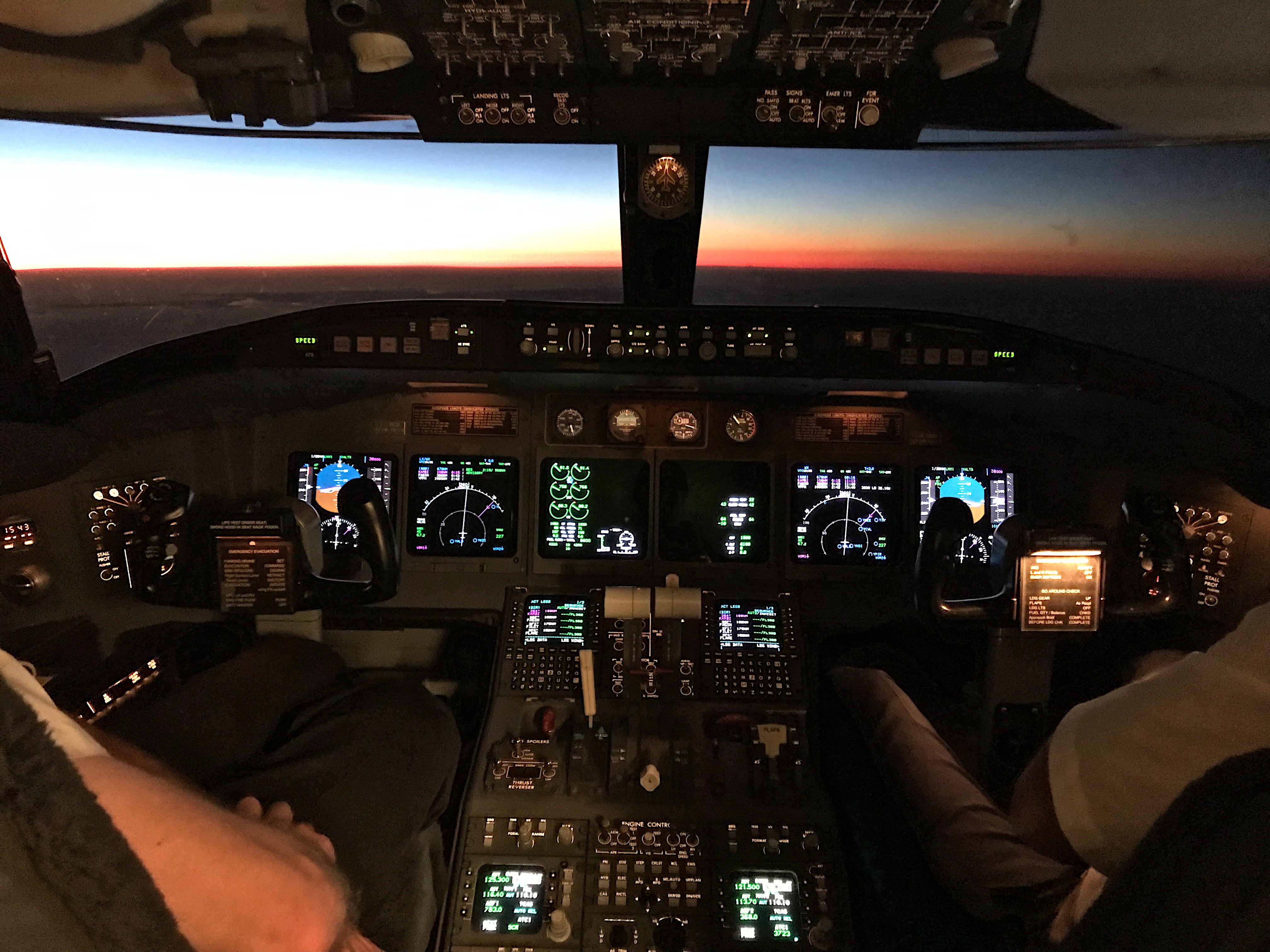 a cockpit of an airplane with a view of the sunset