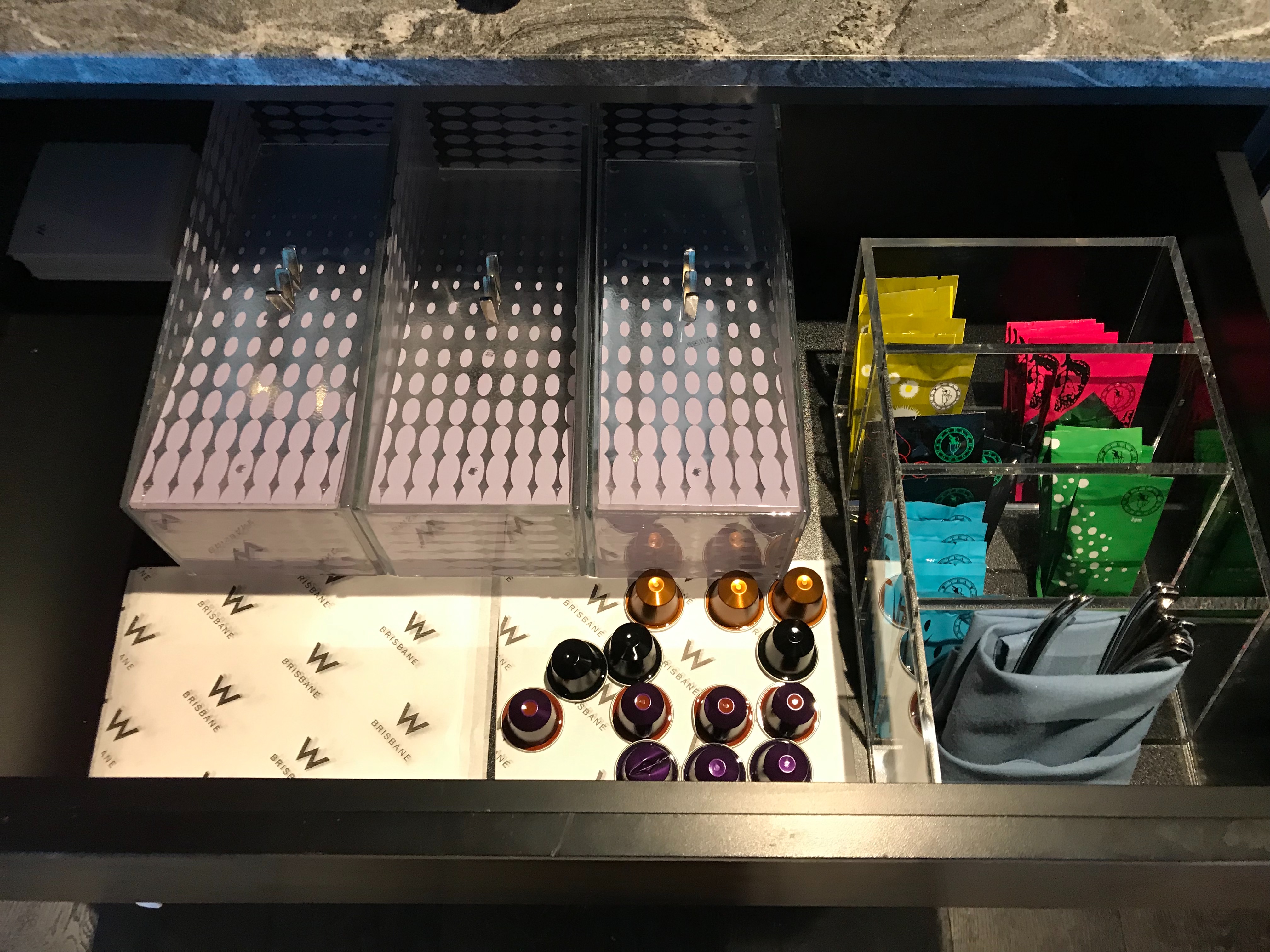 a drawer with multiple boxes and coffee capsules