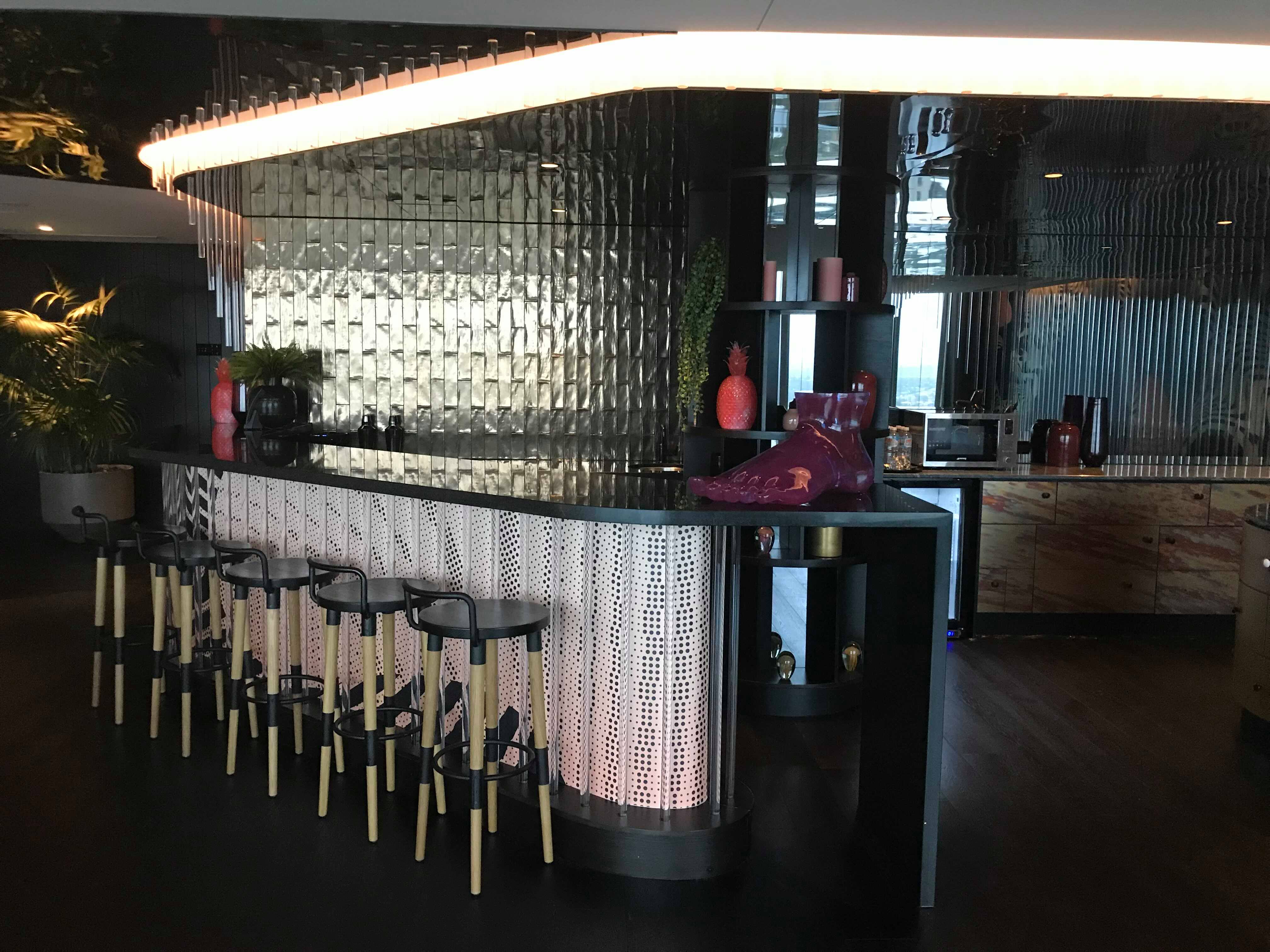 a bar with stools and a light above it
