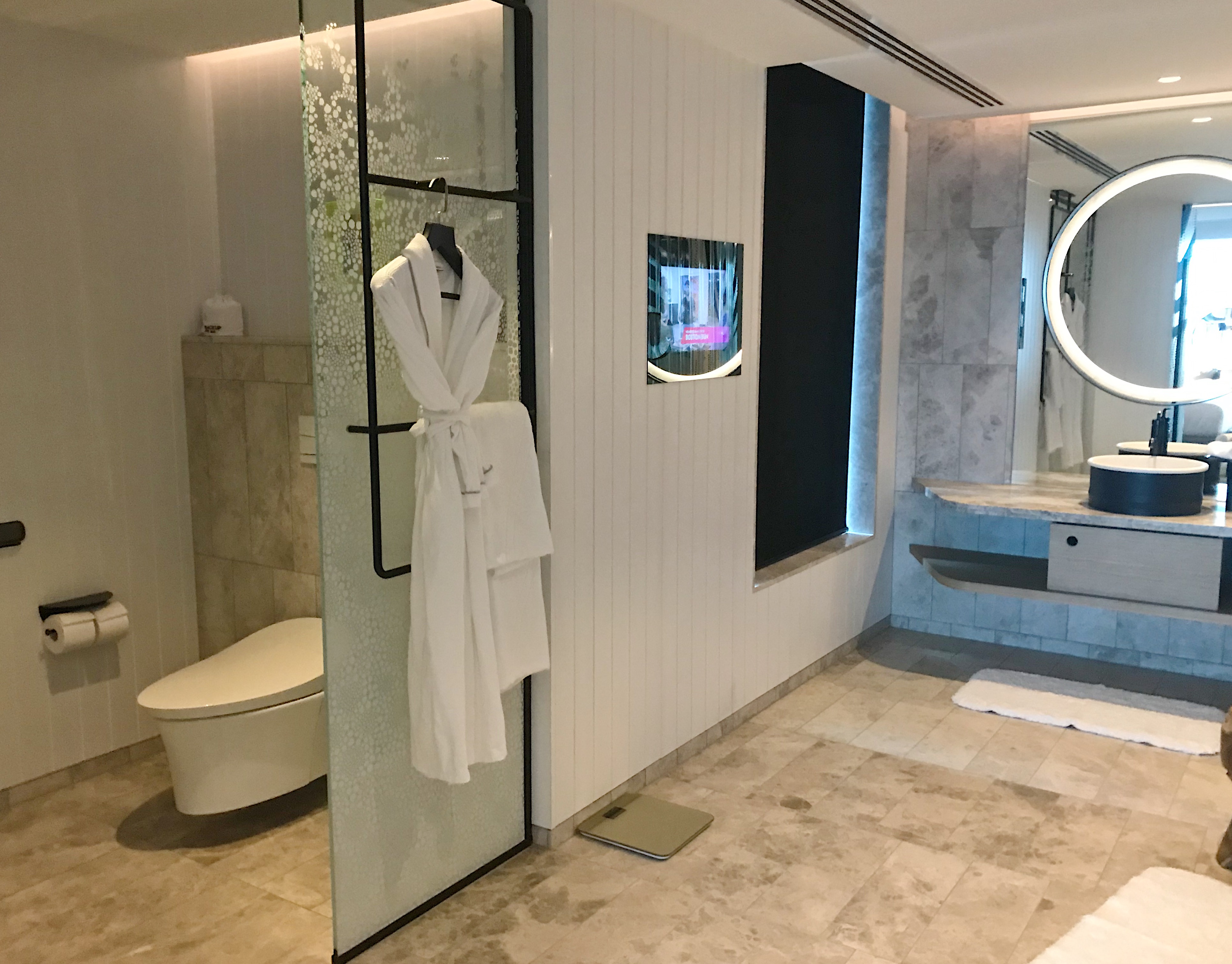 a bathroom with a white robe on a swinger