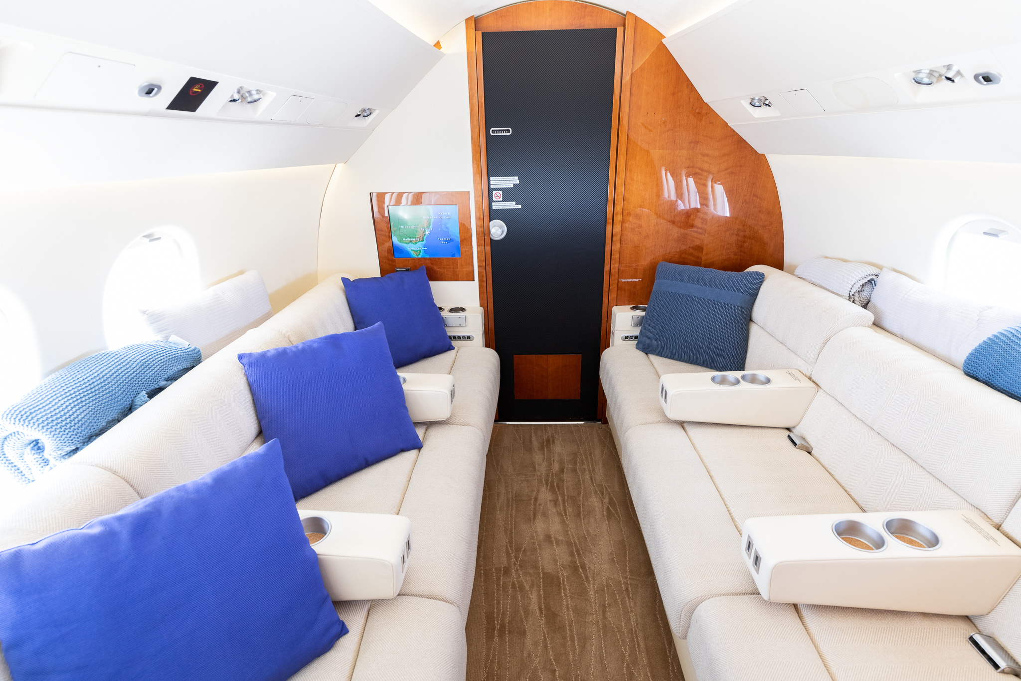 a white couches with blue pillows in a plane