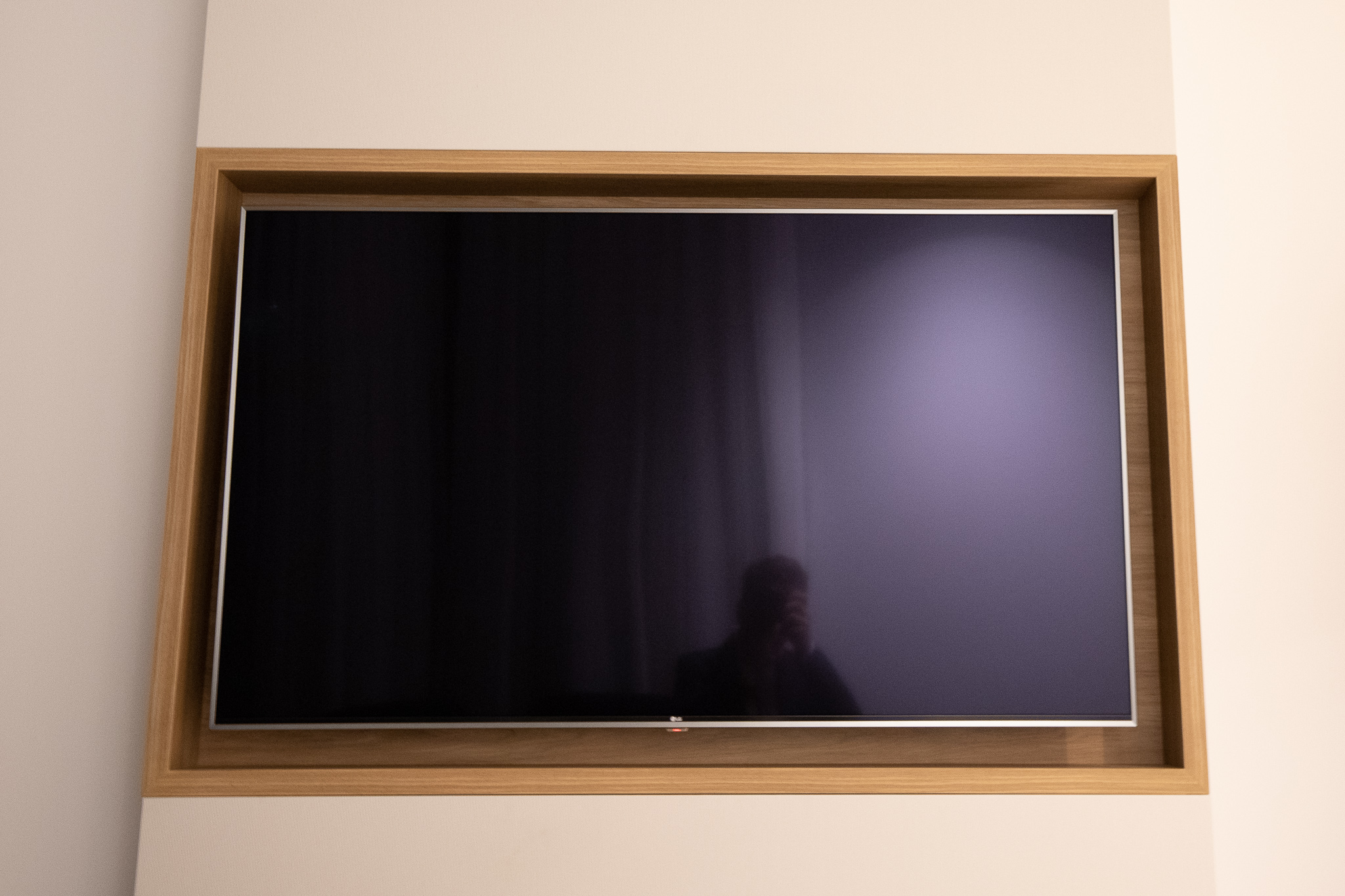 a rectangular wooden frame with a person's reflection in it