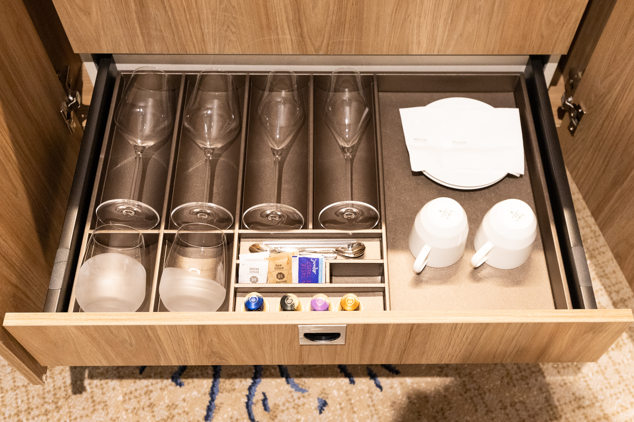 a drawer with wine glasses and cups