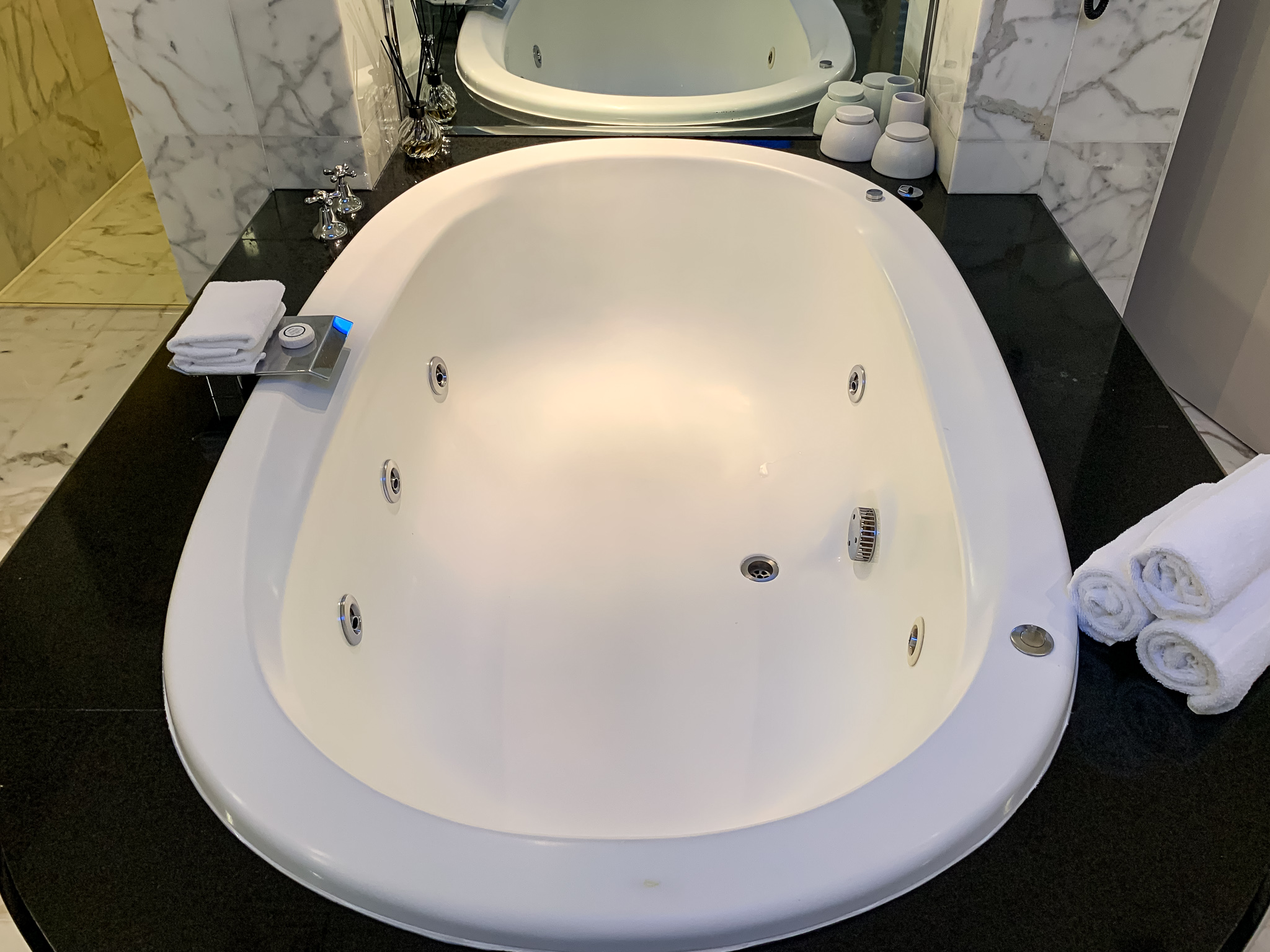 a white bathtub with a mirror above it