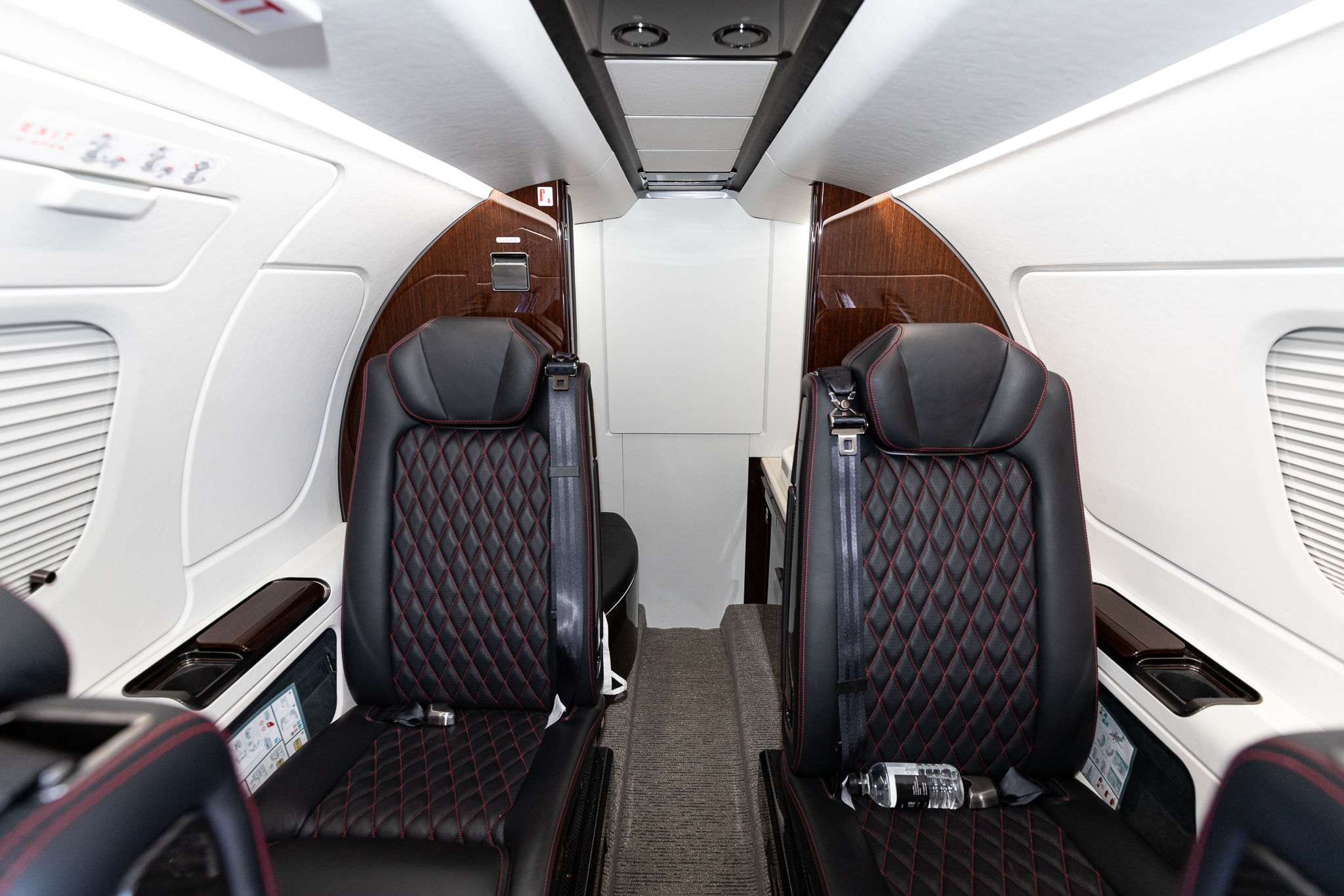 the inside of a plane with black and red seats