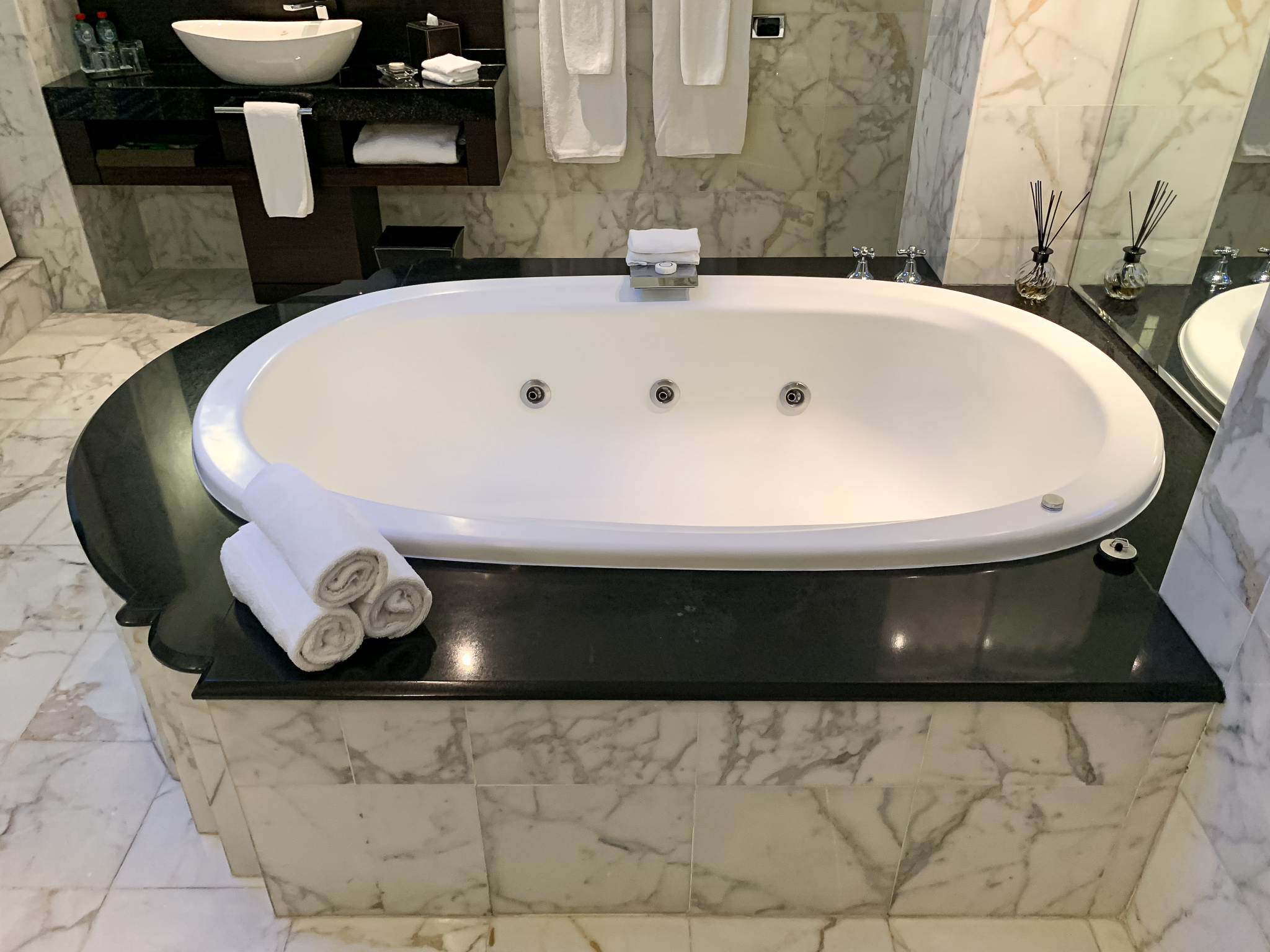 a white bathtub with towels on the side