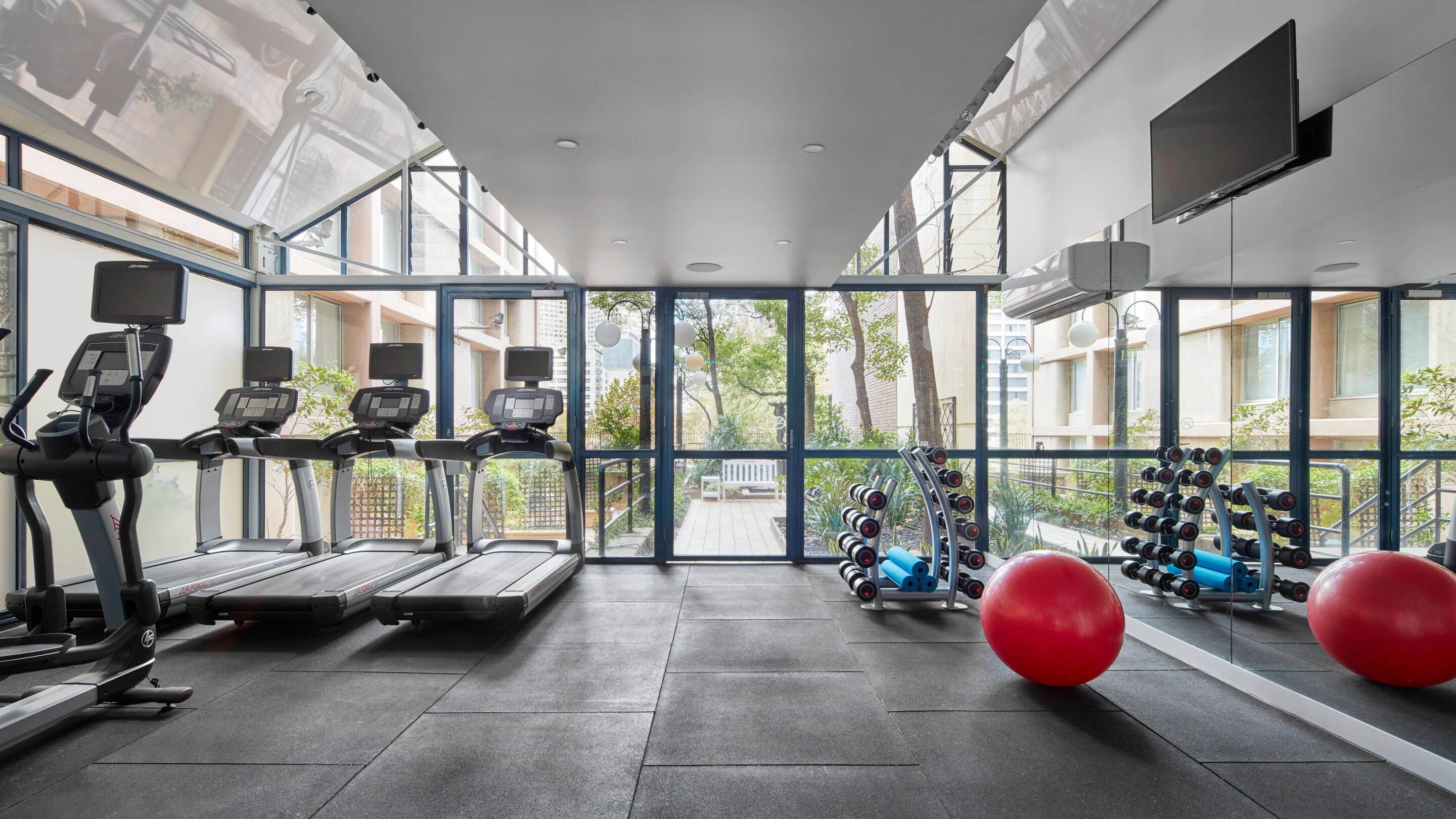 a gym with exercise equipment and a red ball