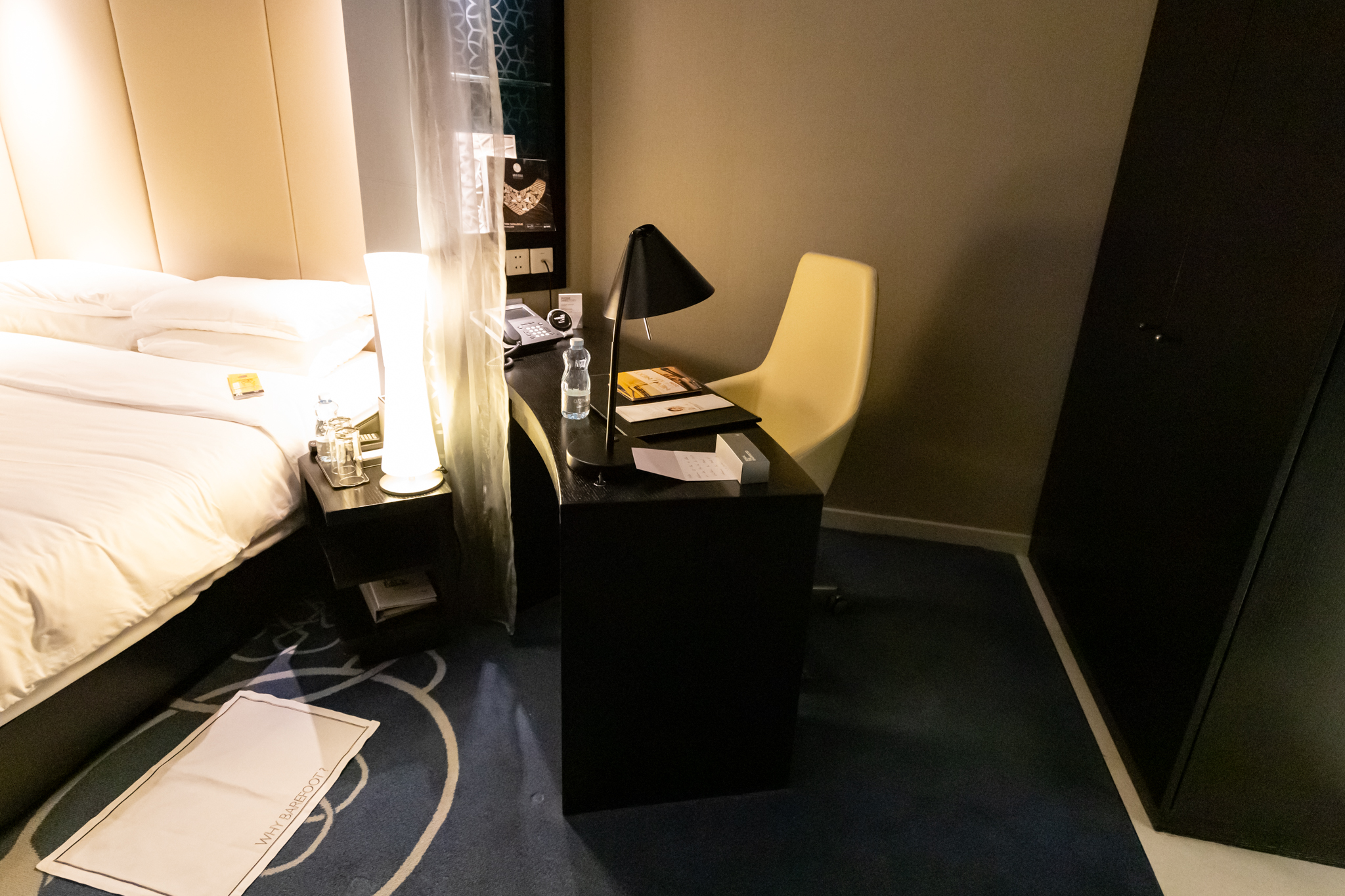 a desk with a lamp and a chair in a room