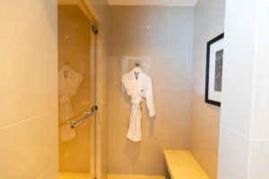 a white robe on a wall in a bathroom