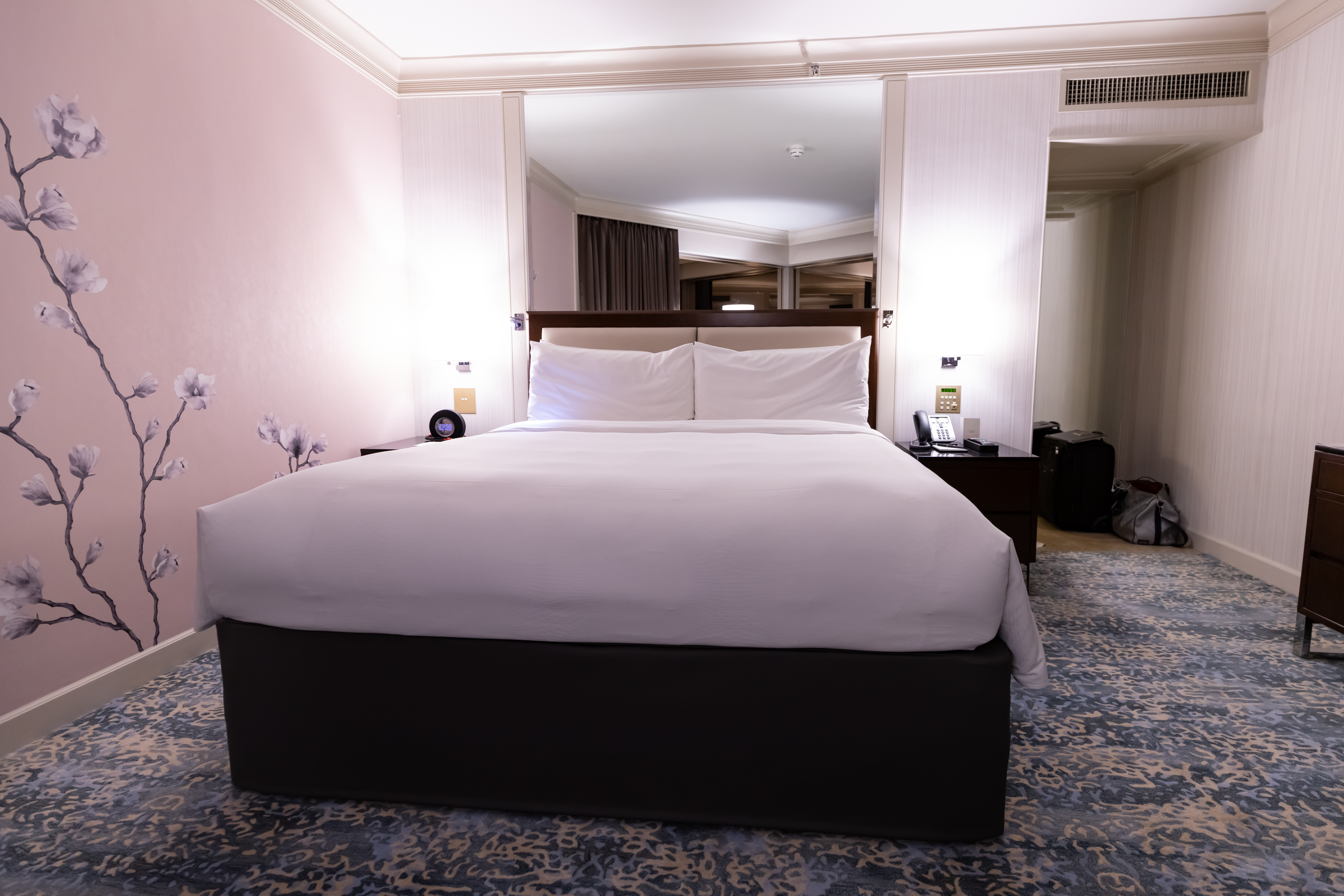 a bed with white sheets and a blue rug