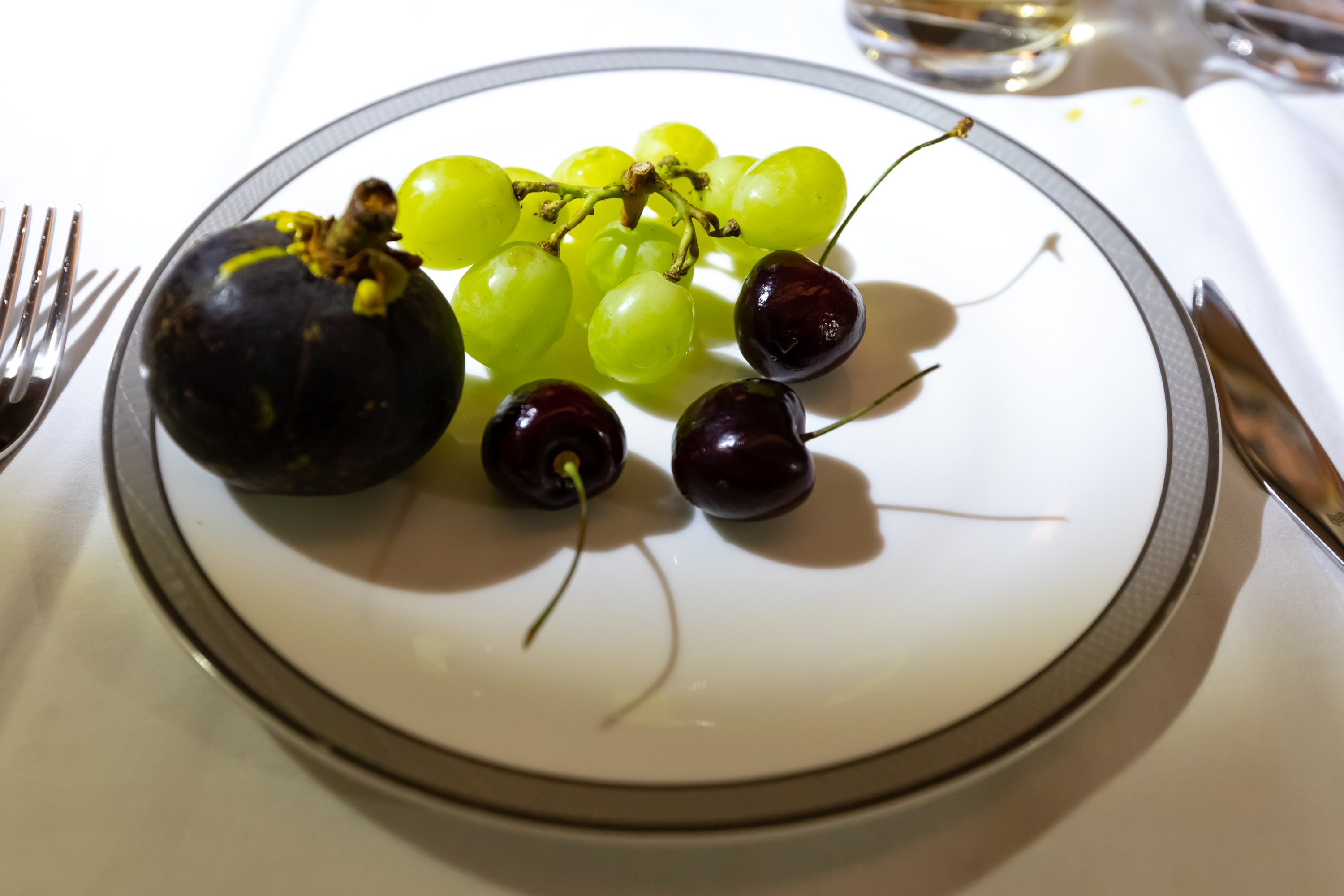 a plate of grapes and cherries