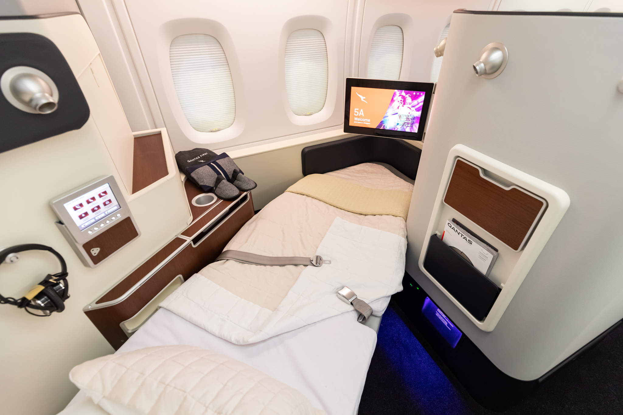 a bed with a tv and a chair in a plane
