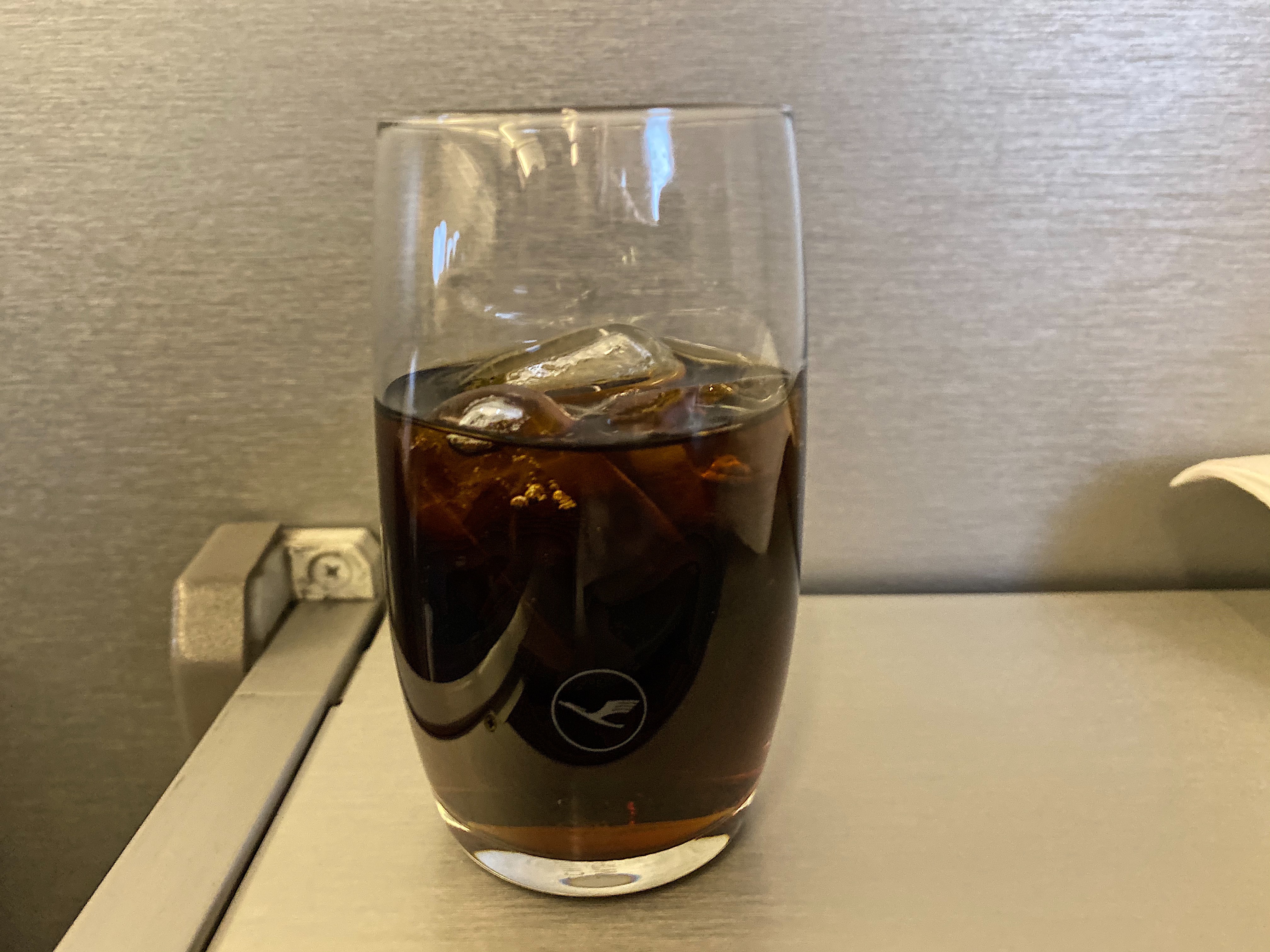 a glass of brown liquid with ice