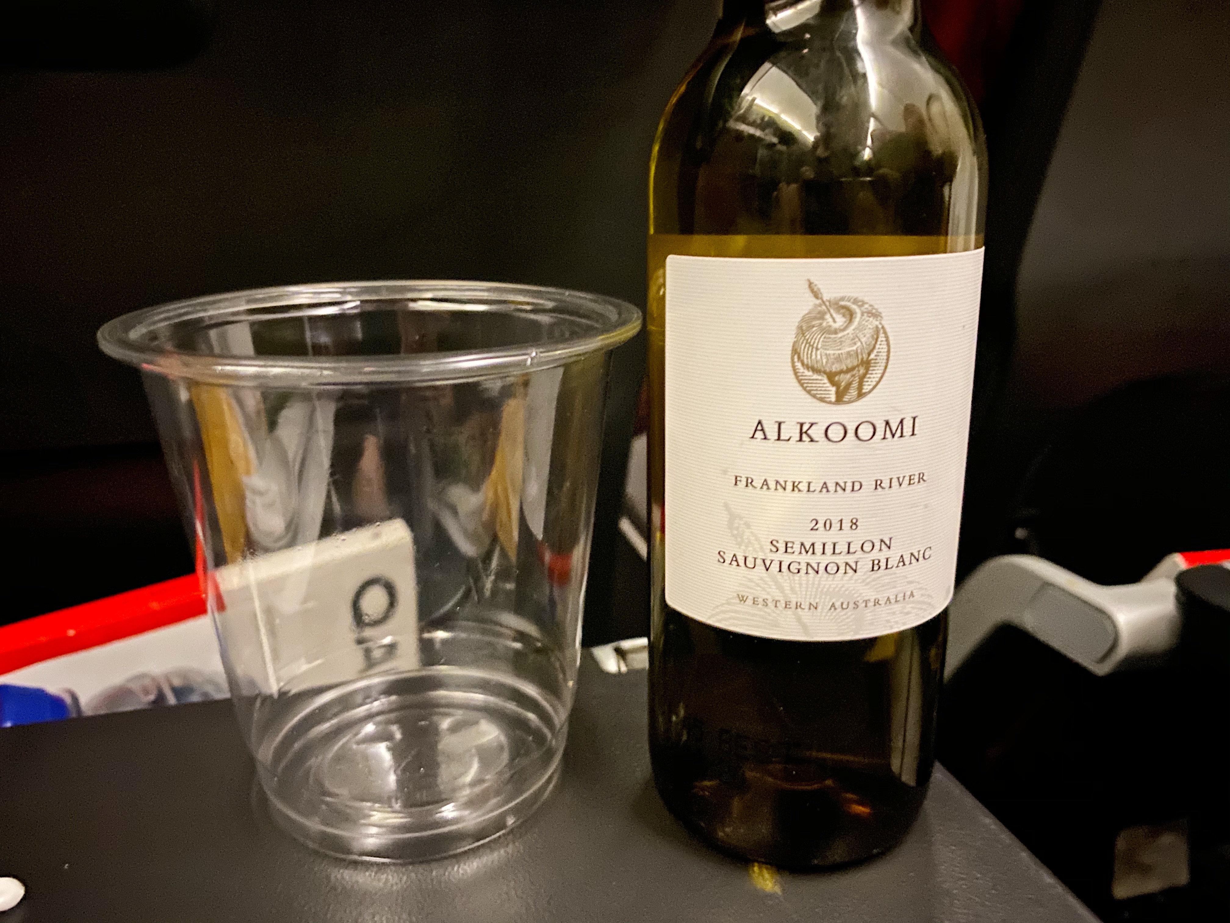 a bottle of wine next to a clear glass