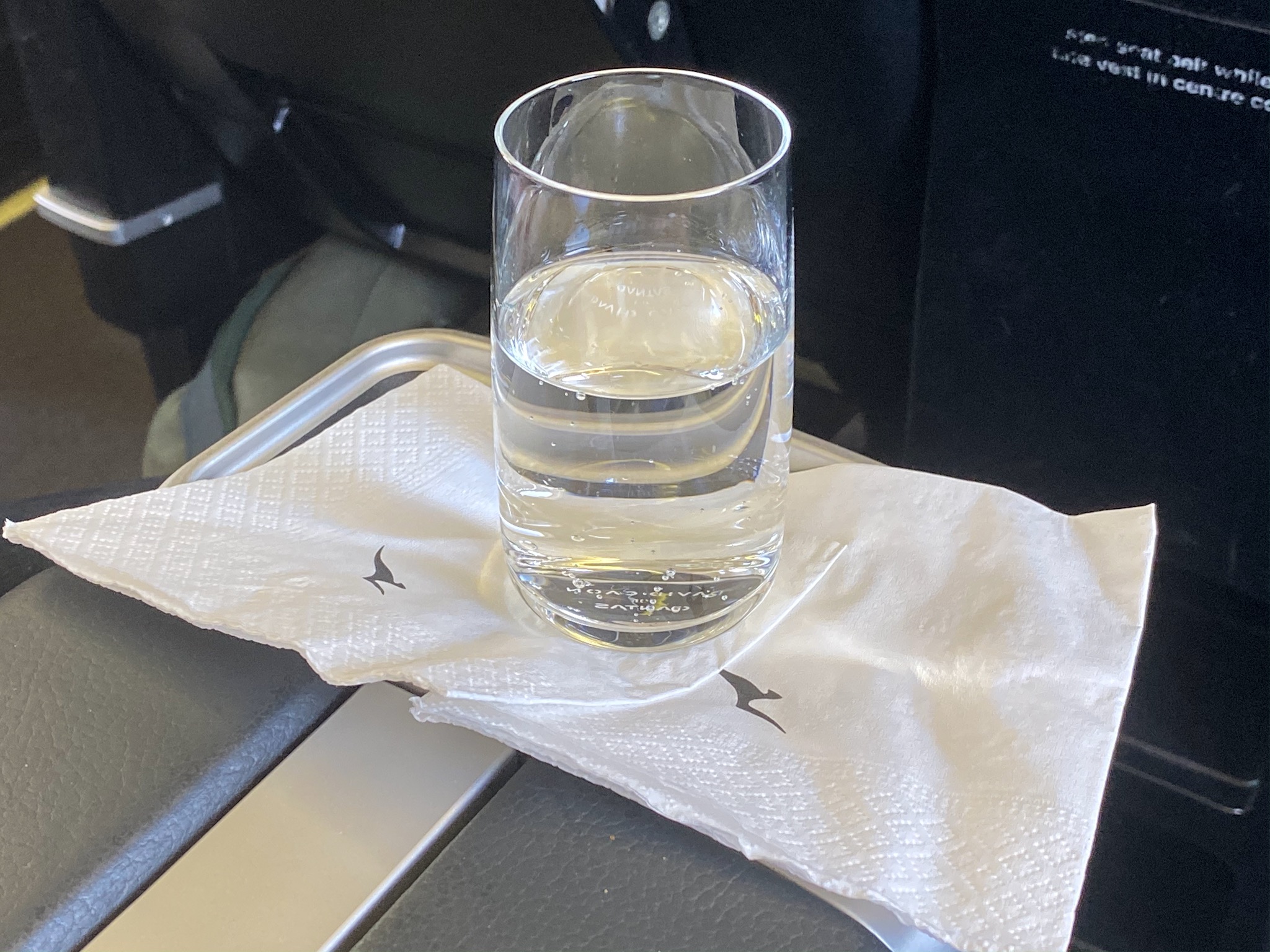 a glass of water on a napkin on a tray