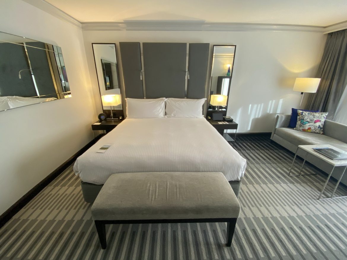 a bed with a bench and a lamp in a room