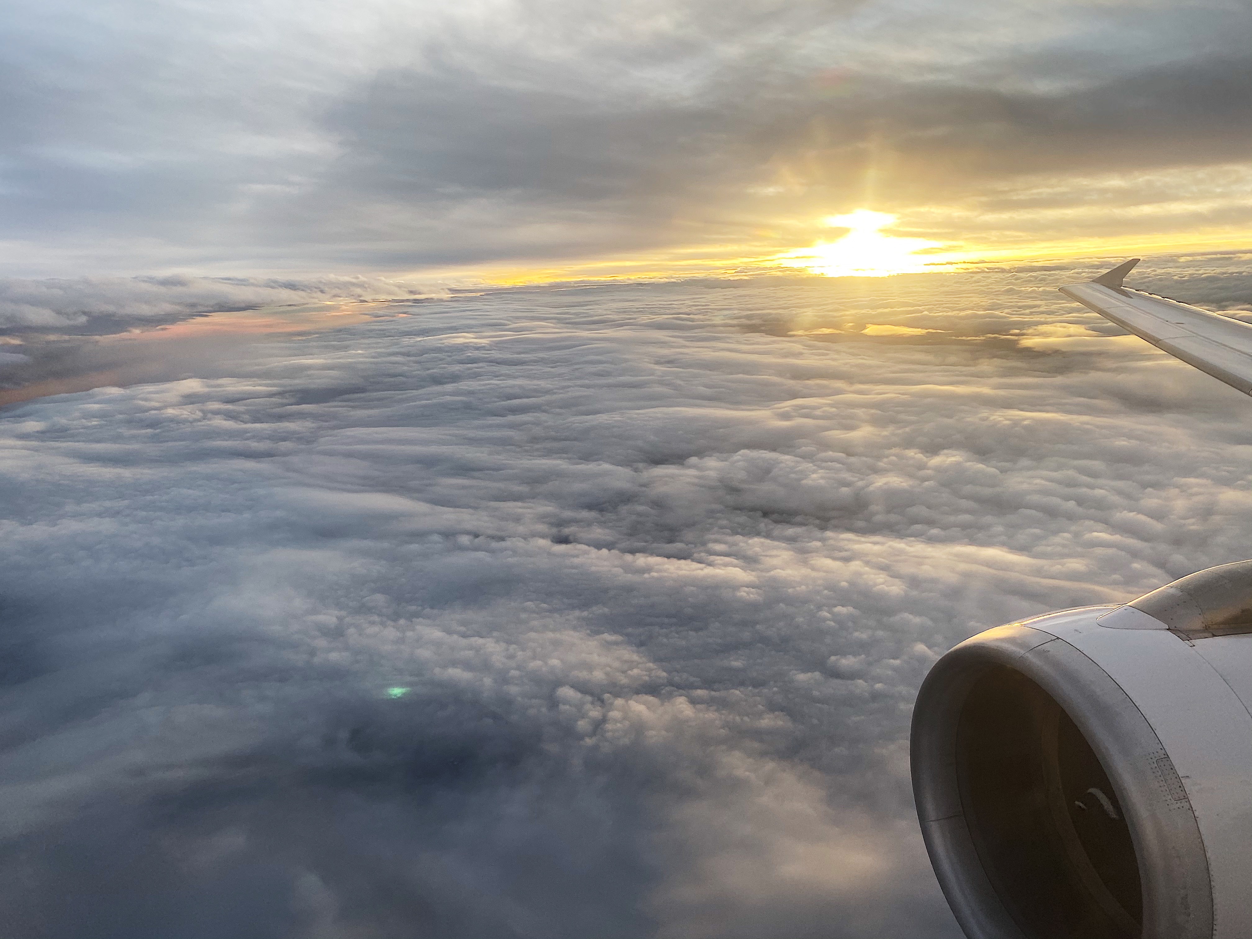 a view of clouds and the sun from an airplane window