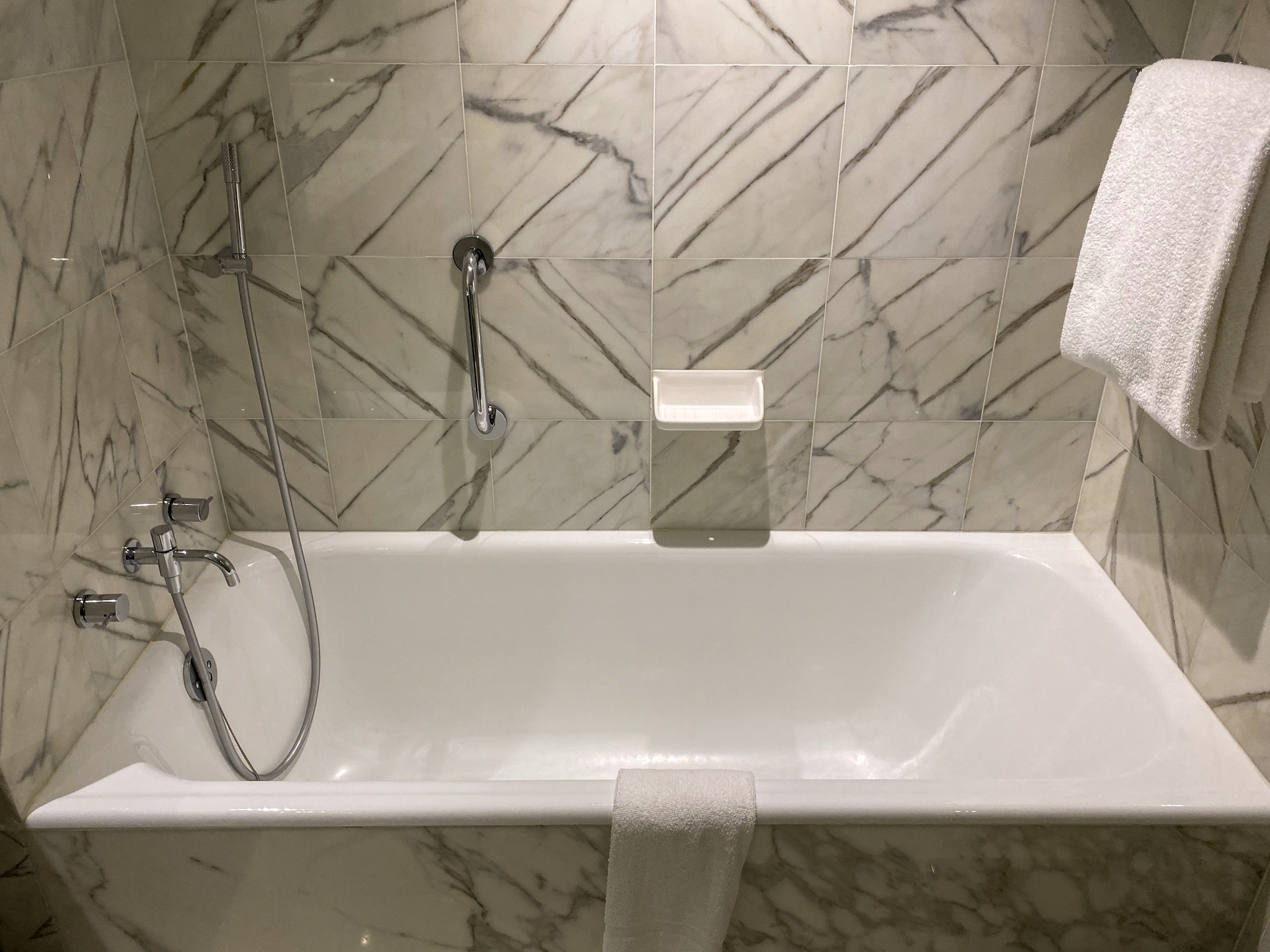 a bathtub with a towel on the wall