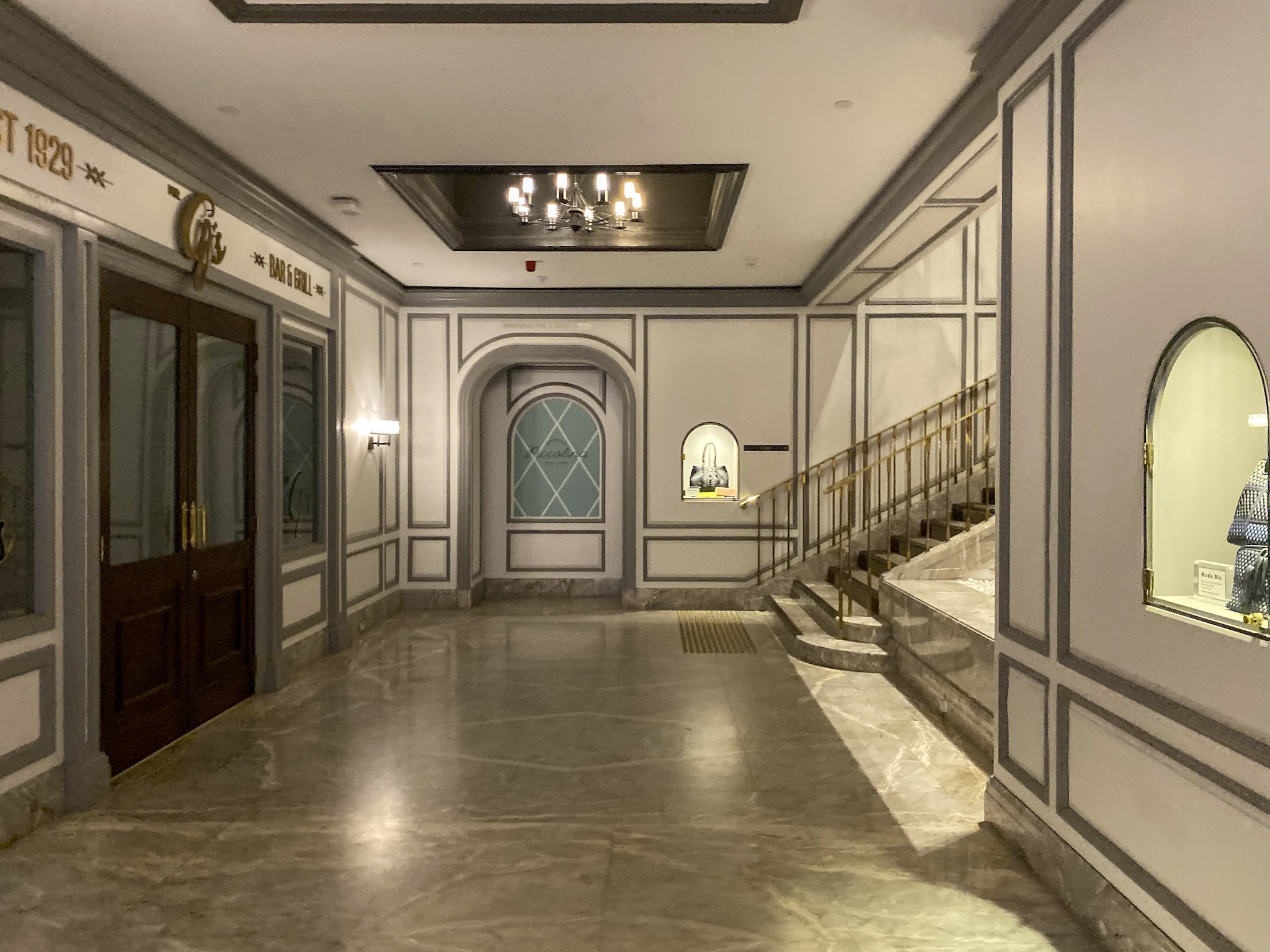 a hallway with marble floor and stairs