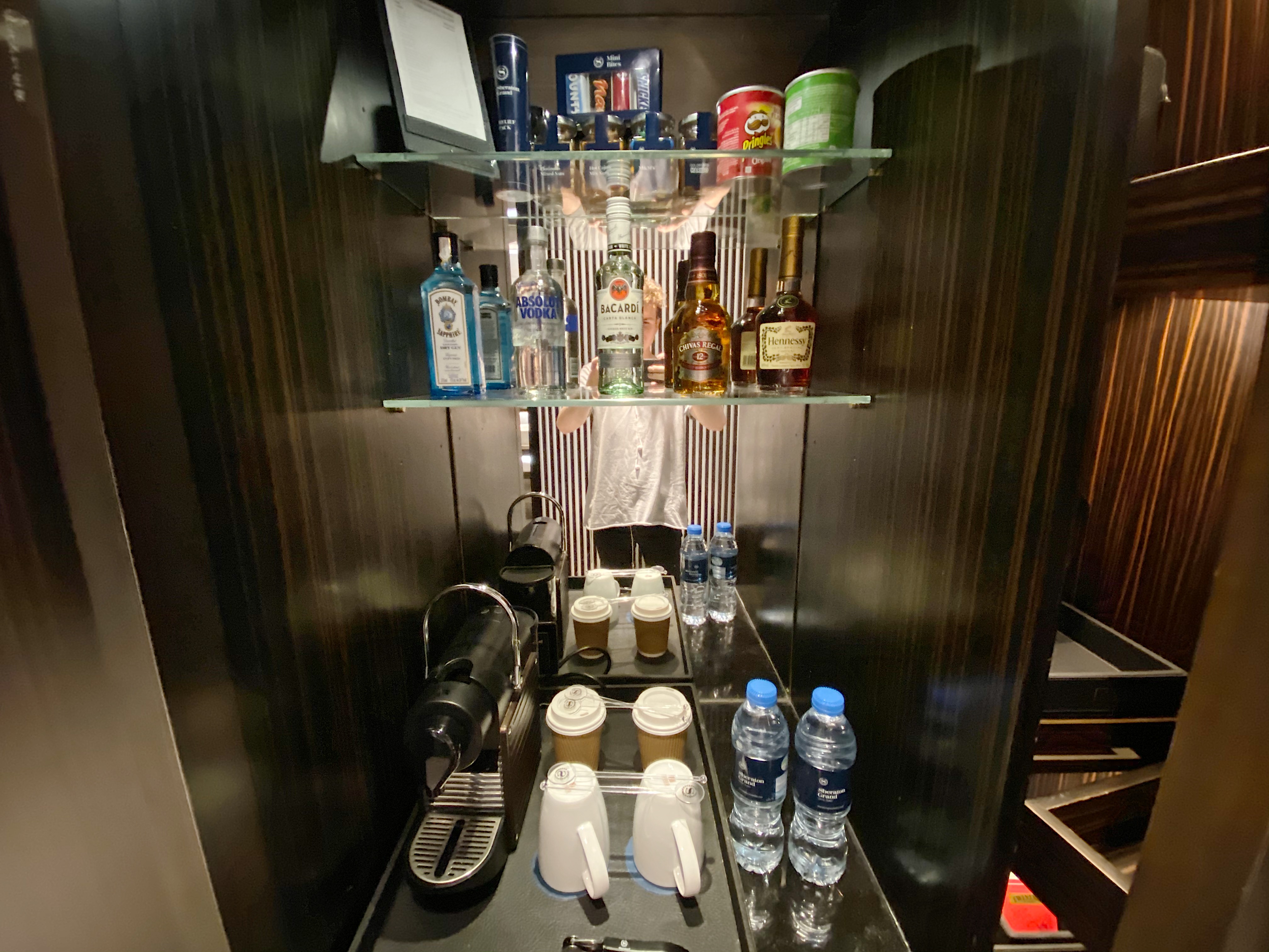 a shelf with bottles and coffee cups