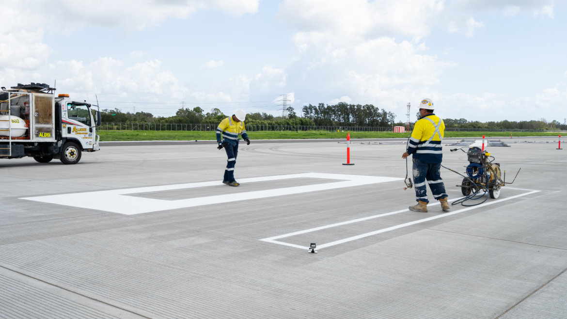 BRISBANEAIRPORTNEWRUNWAY-4 a group of men in hard hats and helmets standing on a concrete surface