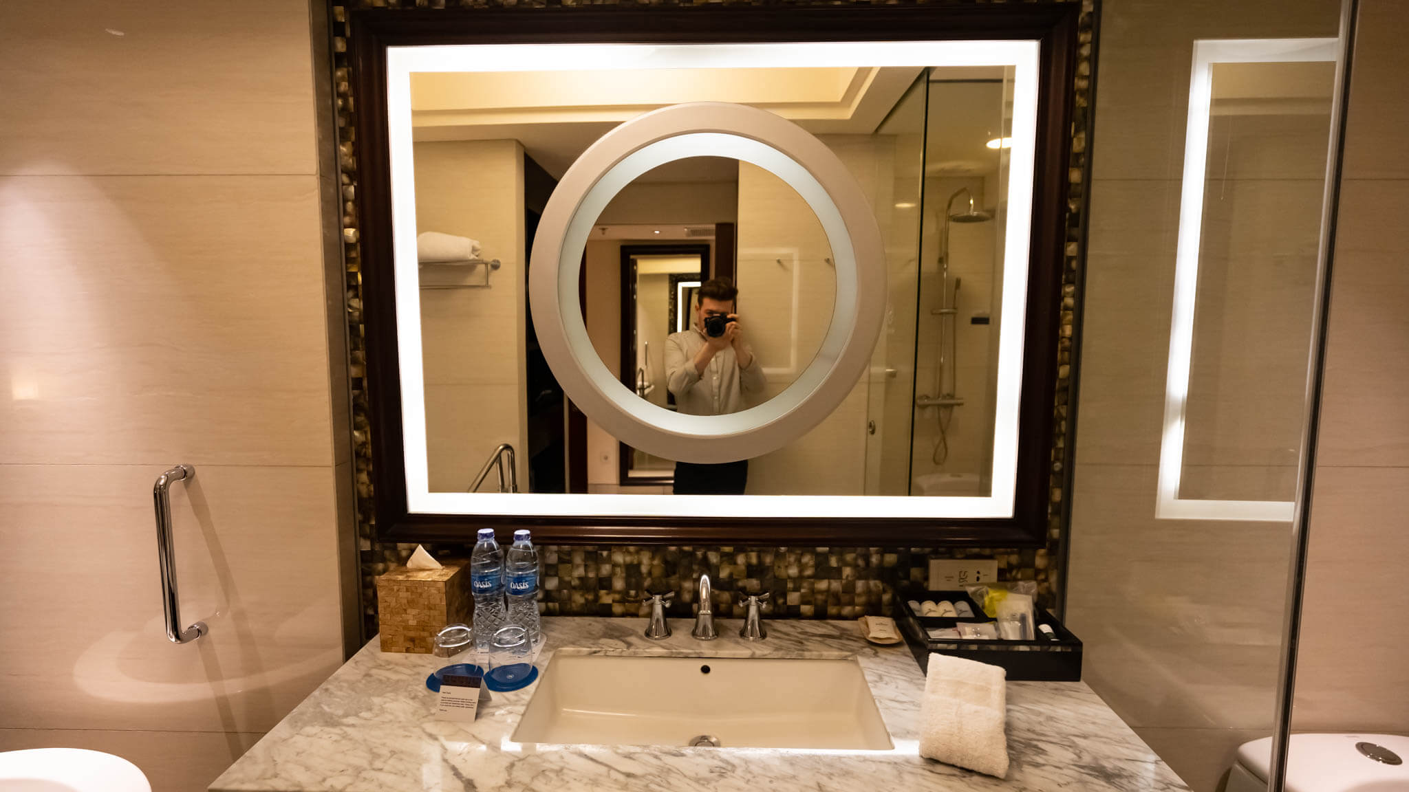 a man taking a picture of himself in a bathroom mirror