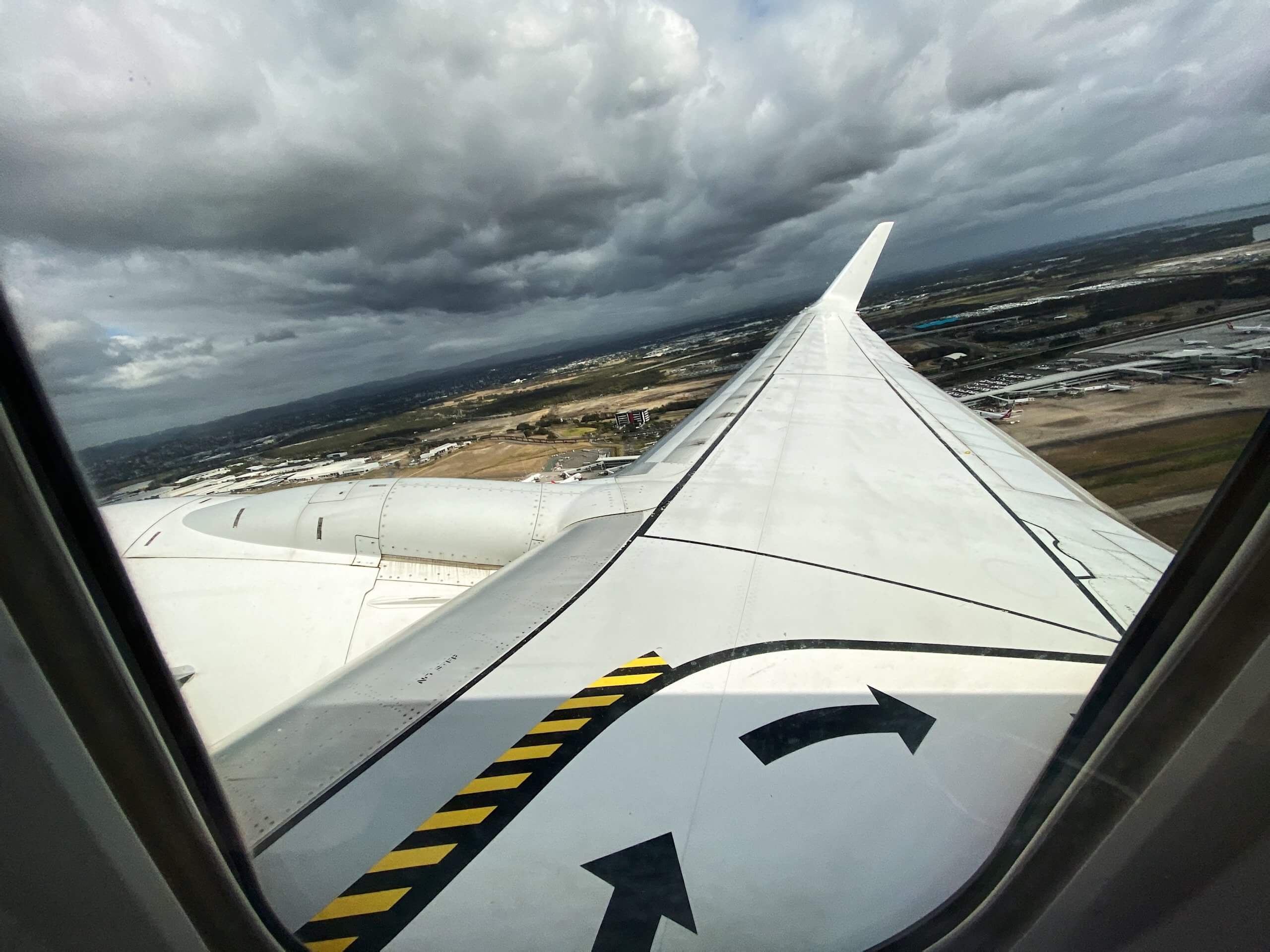 an airplane wing with a cloudy sky