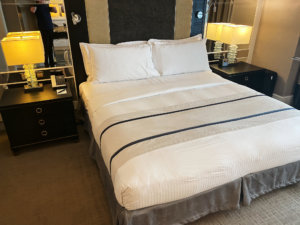 a bed with white sheets and a lamp