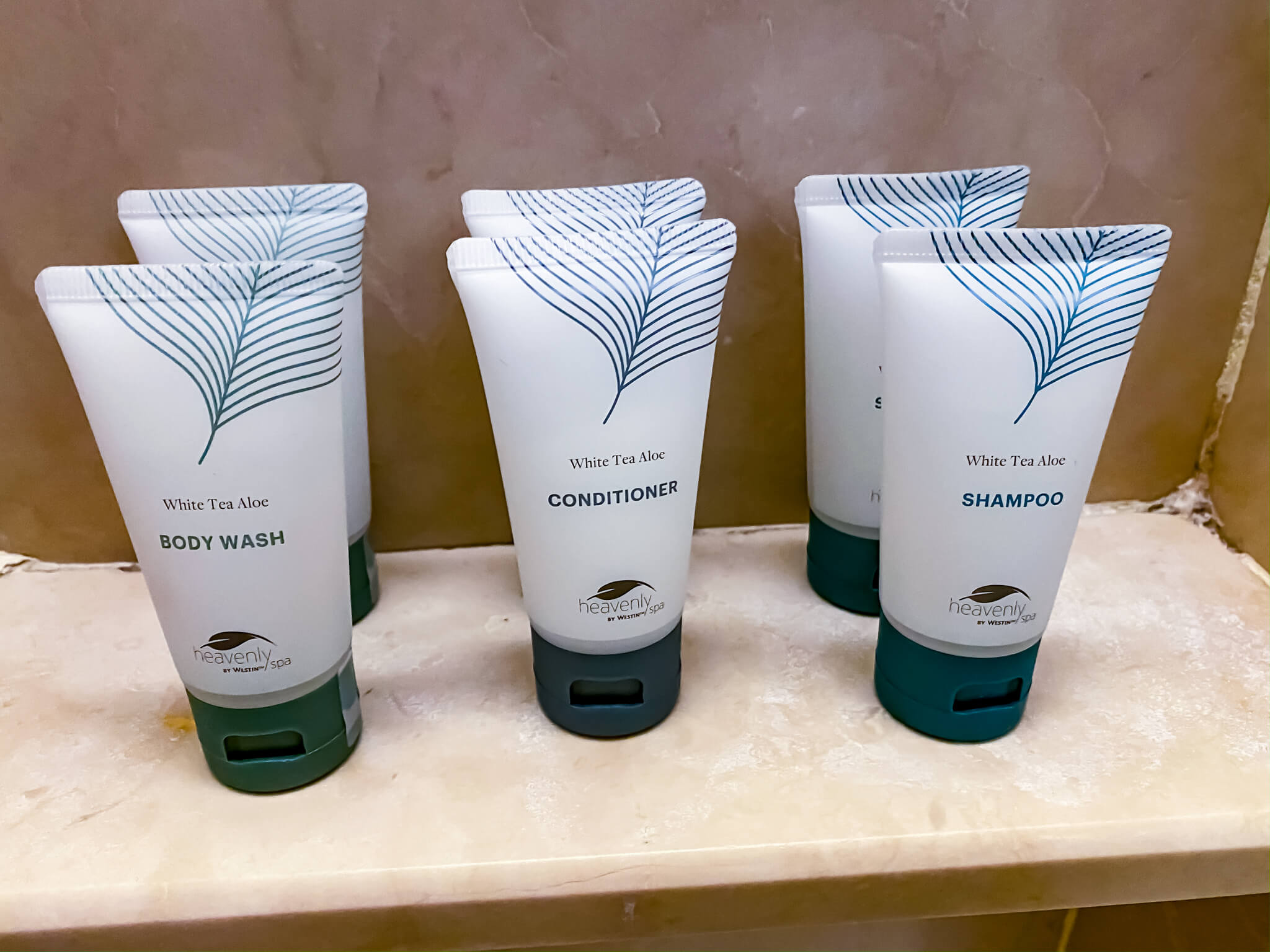 a group of white and blue bottles of shampoo and conditioner